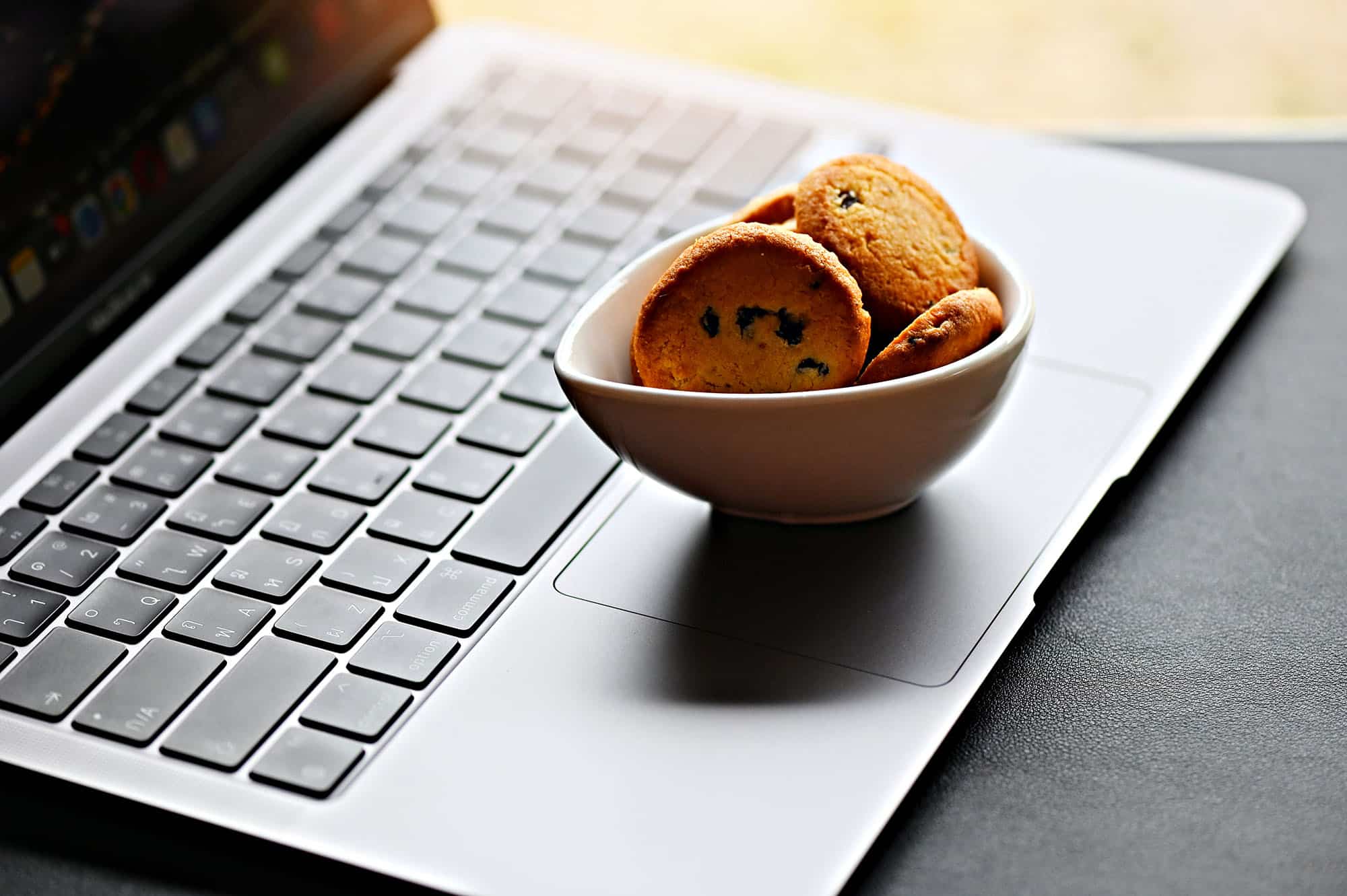 Cookies in a bowl on a laptop keyboard