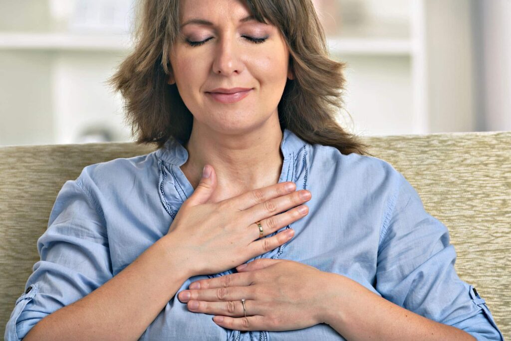 Woman practising mindfulness meditation with hands on heart