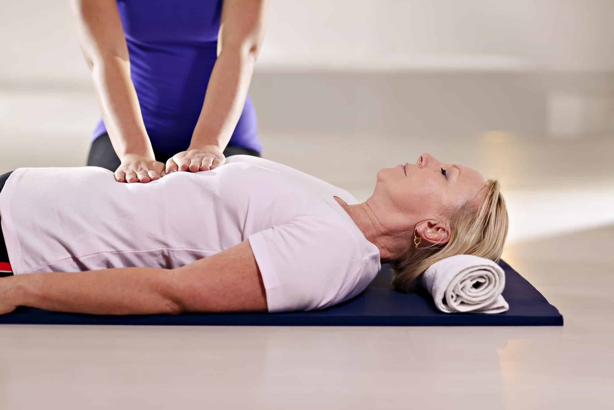 Person practising CPR on a manikin in a healthcare setting