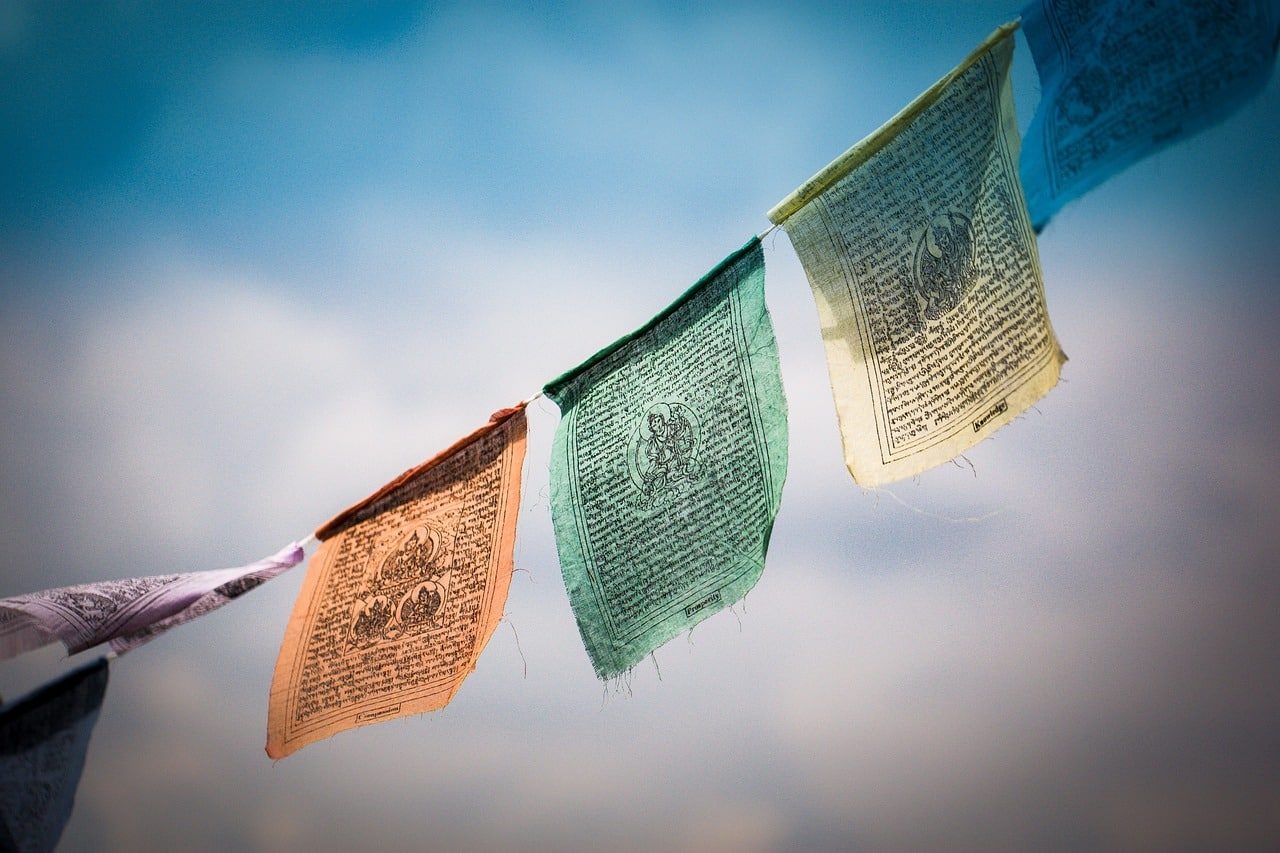 Colourful Tibetan prayer flags fluttering against a blue sky